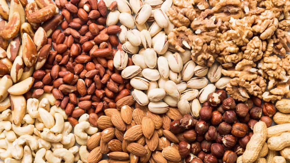 different nuts background. Close up, top view, flat lay. Walnut, pistachios, almonds, hazelnuts and cashews