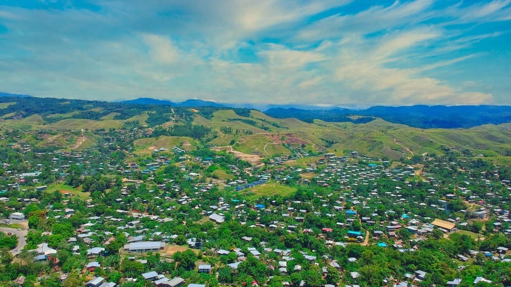 An aerial of houses and nature with the background of mountains in East Honiara, Solomon Islands