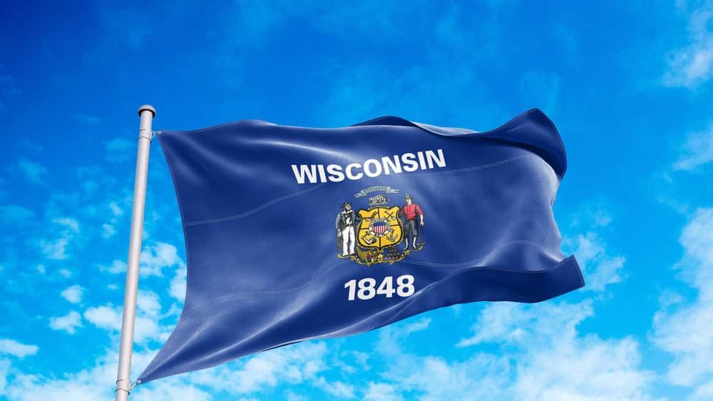 Wisconsin flag waving in the wind, blue sky background