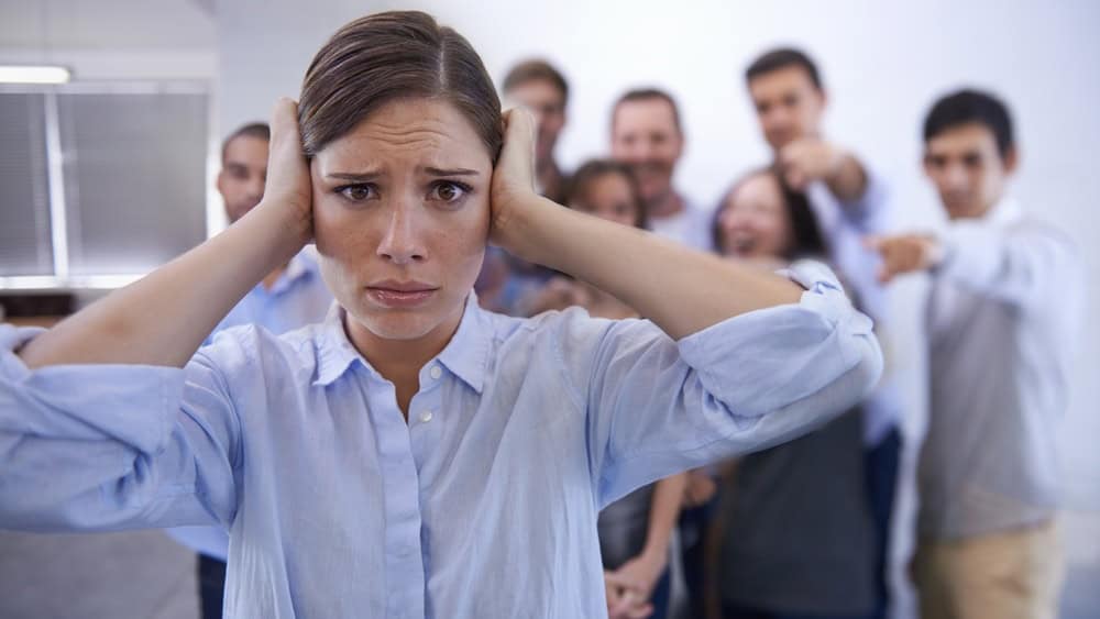 Business, bullying and portrait of woman with stress in office with harassment, prank or hand pointing mock. Judgment, joke and face of worker with new job judgment, shame or corporate gossip victim