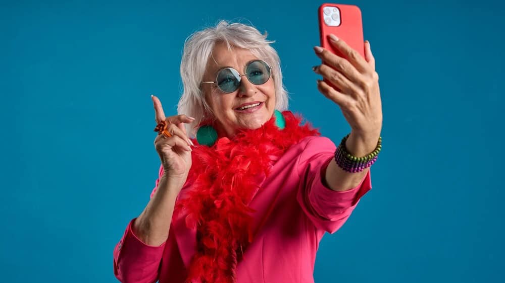 Senior lady capturing the moment on smartphone - Senior selfie concept