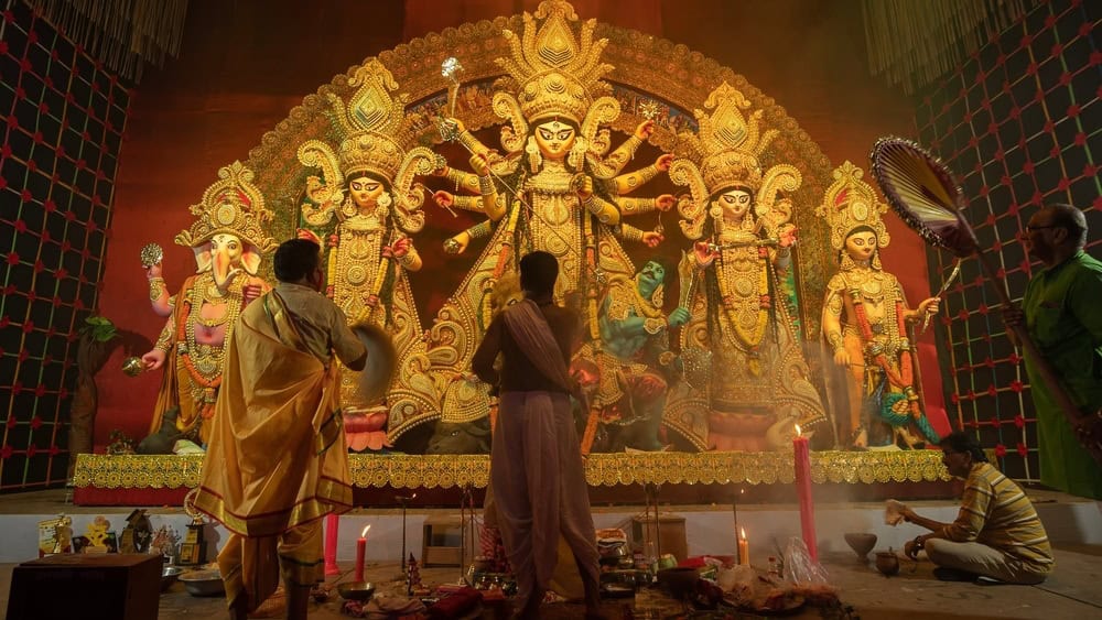 Howrah, West Bengal, India - 3rd October, 2022 : Hindu Priests worshipping Goddess Durga with conch shell. Ashtami puja aarati - sacred Durga Puja ritual- festival of Hinduism performed at night.