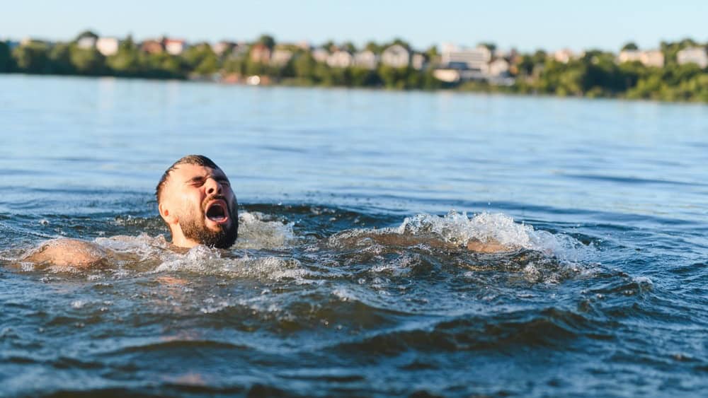Bearded man struggling in a lake, screaming for help while battling panic and fear, facing the desperate fight for survival