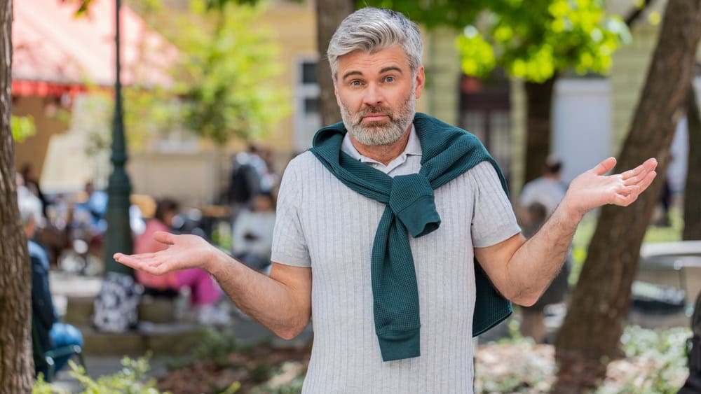 I don't know what to say. Confused mature man feeling embarrassed about ambiguous question, having doubts, no idea, being clueless uncertain outdoors. Caucasian adult guy standing in urban city street