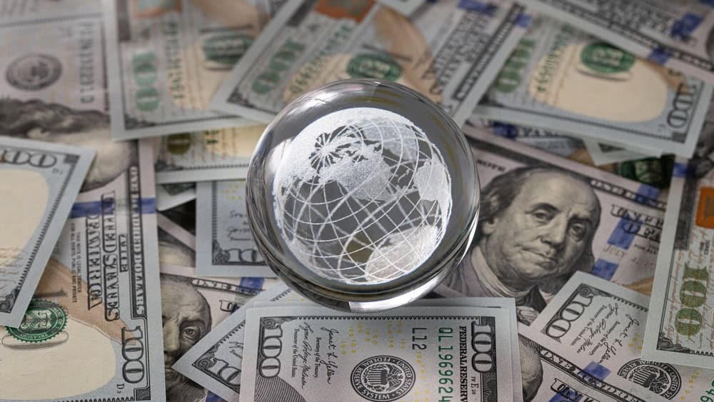 Glass Globe Crystal Ball on Scattered US One Hundred Dollar Banknotes Background