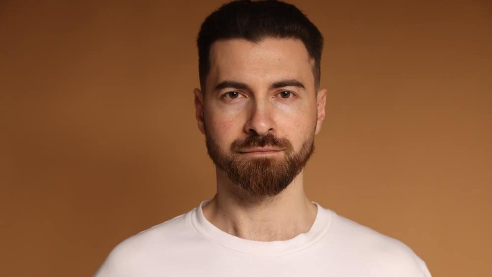 Portrait of bearded man on beige background