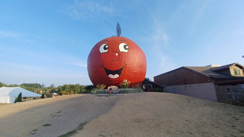 Ottawa, ON, Canada - August 10, 2025: Giant apple landmark with a smiling face welcoming visitors, a popular destination and iconic roadside attraction in Canada