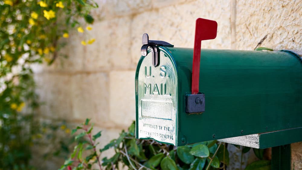 Green US post mail letter box with red flag raised up