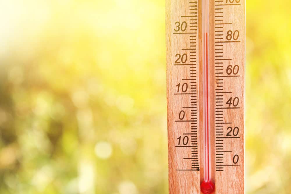 Thermometer displaying high 30 degree hot temperatures in sun summer day.