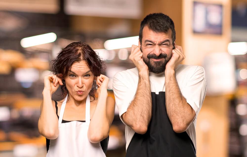 Couple of cooks covering ears with hands