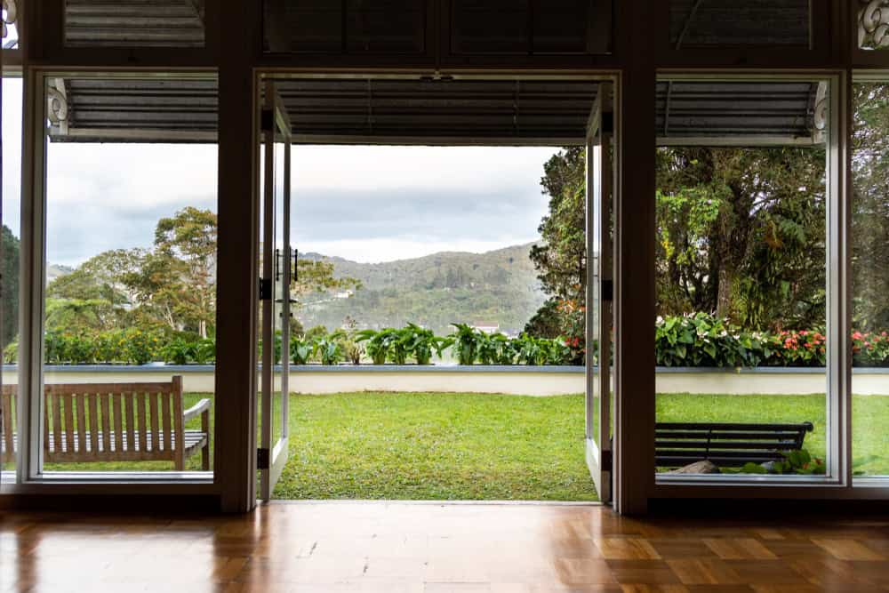 Refreshing, green, nature landscape view from home through glass door in highland