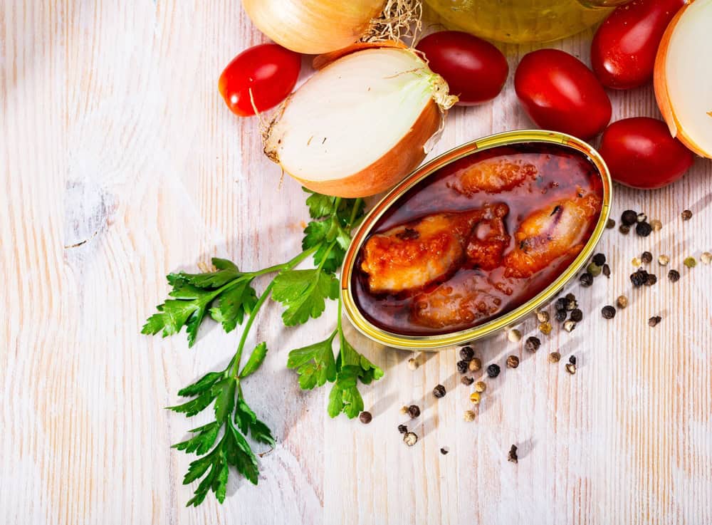 Canned stuffed squids in American sauce served on table