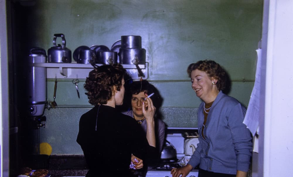 London UK, 21st December 1953:An extremely old vintage photo from 1959 showing a British kitchen with women and house wives chatting and talking while smoking a cigarette 