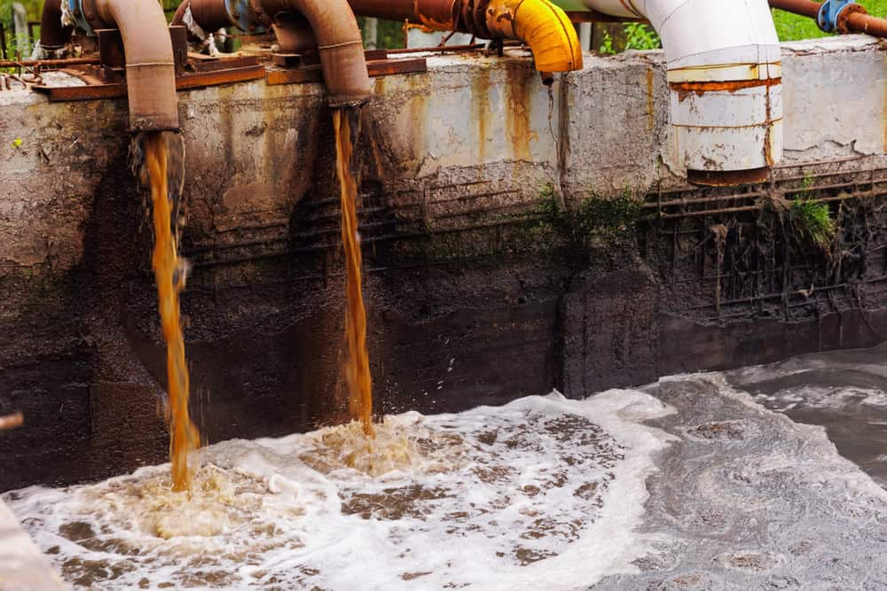 Pipes with waste water of industry is discharged into river.