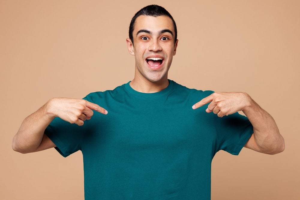 Young shocked excited middle eastern man wear blue t-shirt casual clothes point index finger on himself look camera isolated on plain pastel light beige background studio portrait. Lifestyle concept