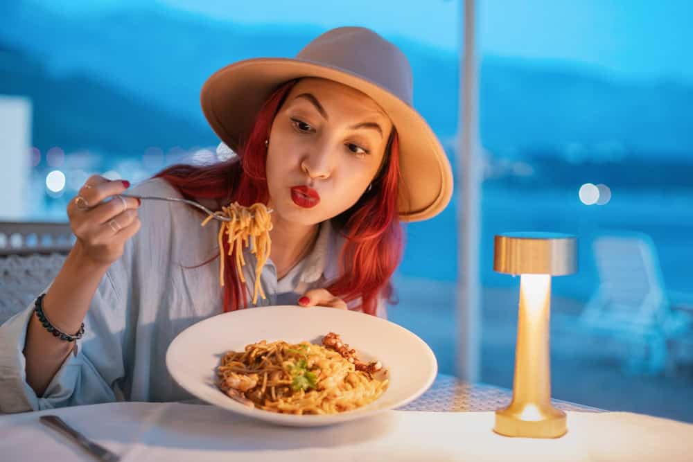 Tourist savoring delicious seafood spaghetti in a charming seaside restaurant