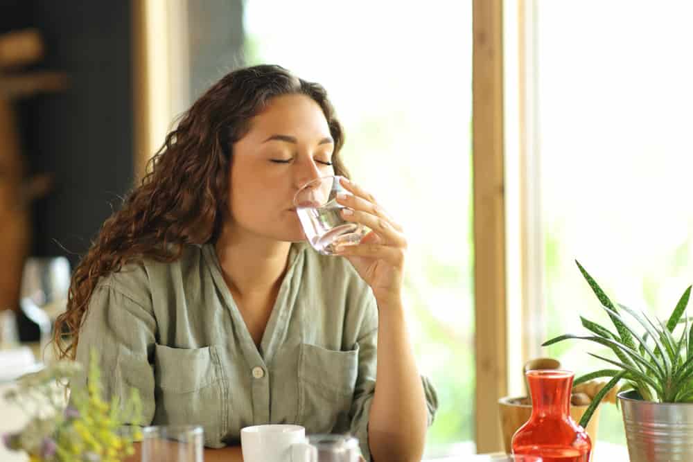 Relaxed woman in a restaurant drinking water