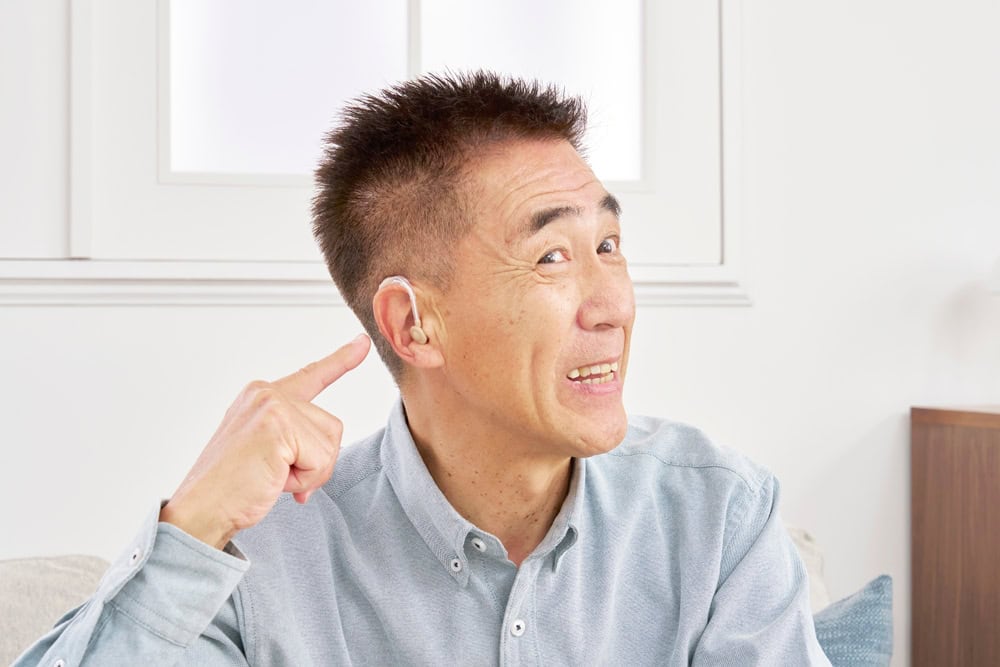 Asian senior man with hearing aid in the living room