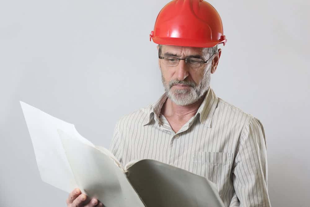 Portrait of an engineer, Portrait of an engineer with helmet and project papers, studio shoot