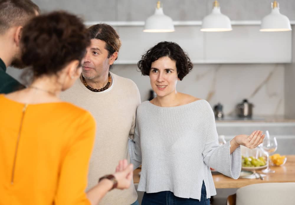 Husband and wife stand side by side and say goodbye to guests, accompany couple and thank them for evening together.